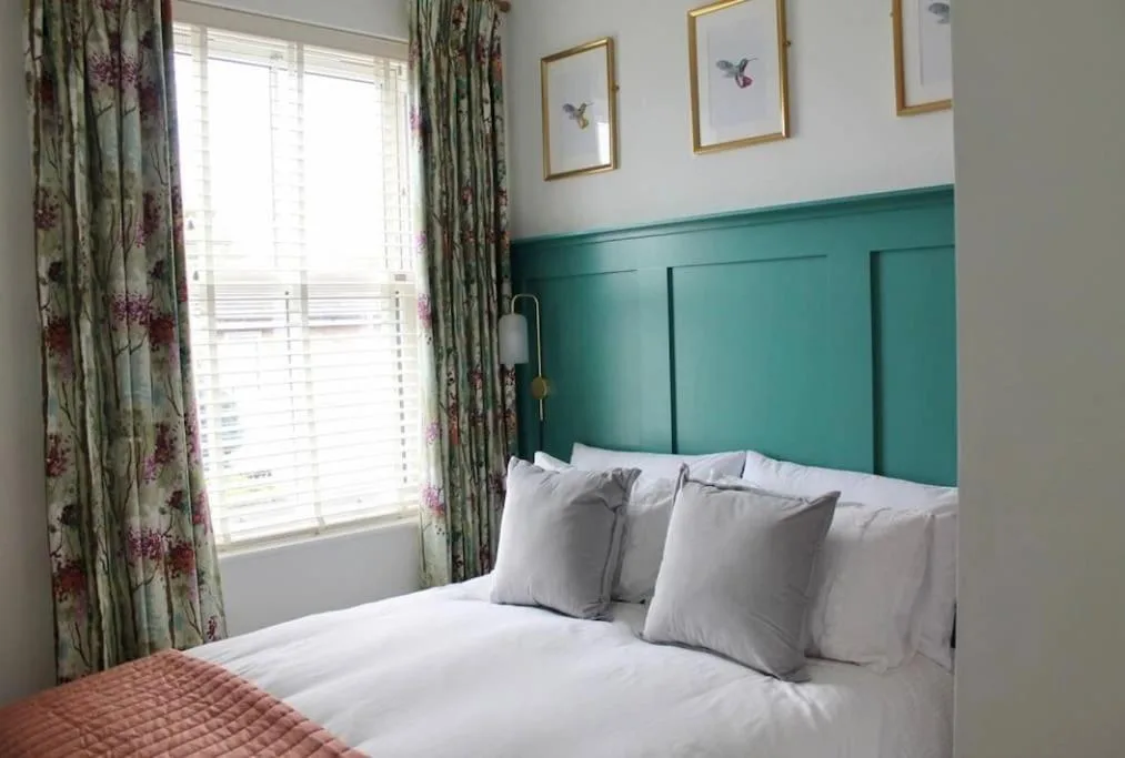 a bedroom with a bed with white pillows and a window at Clement House, York, Free EV and parking in York