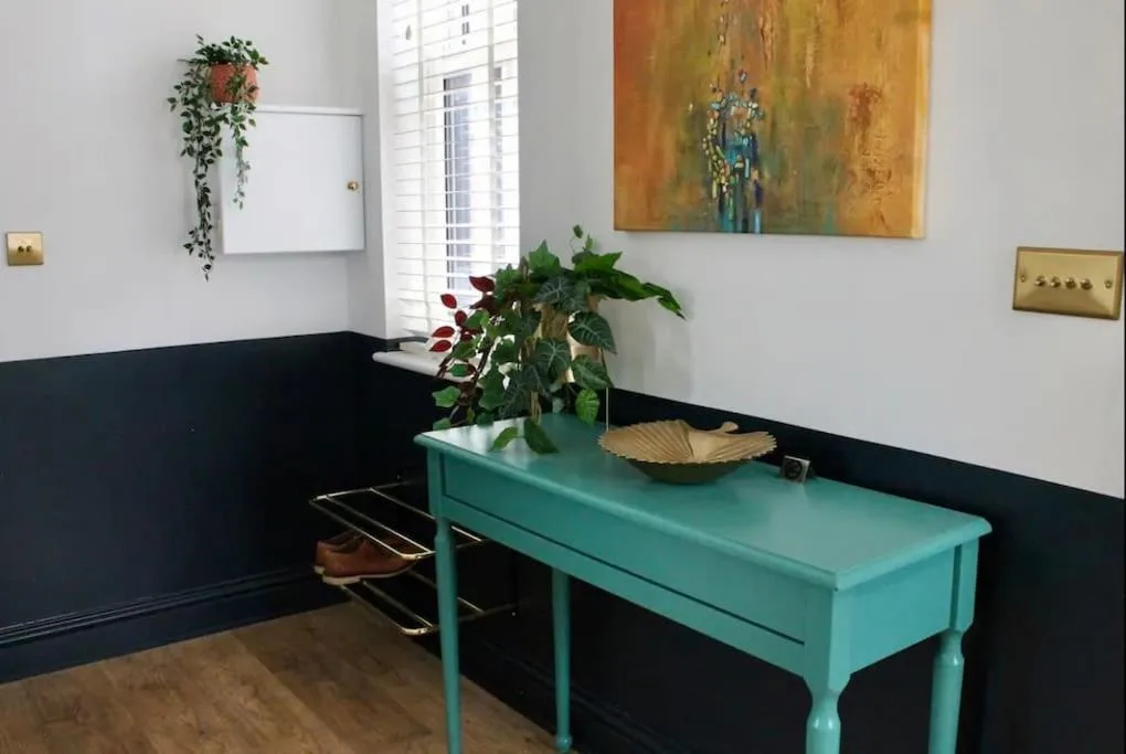 a blue table in a room with a potted plant at Clement House, York, Free EV and parking in York